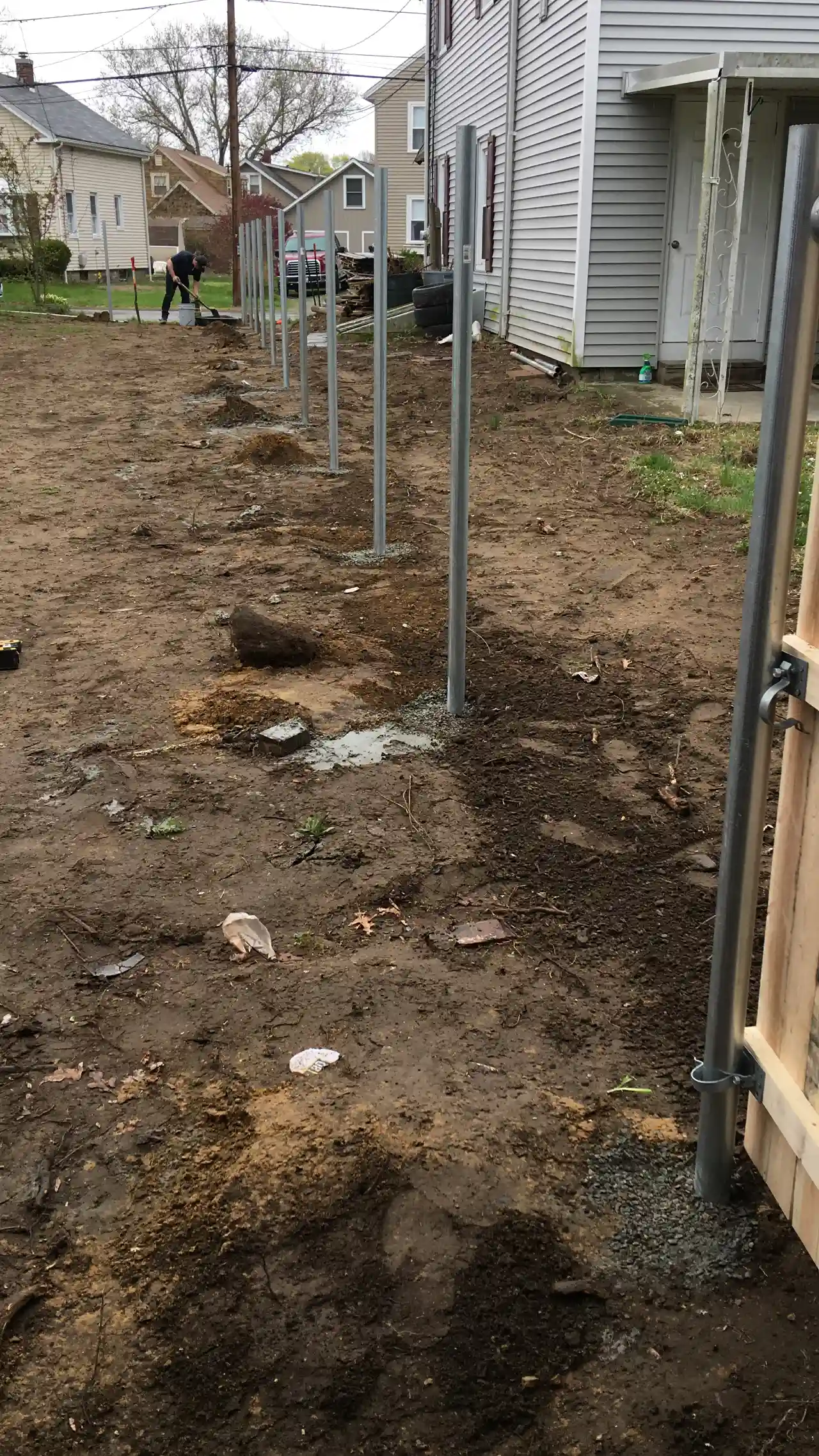 Fence posts set along a property line during installation in Massachusetts