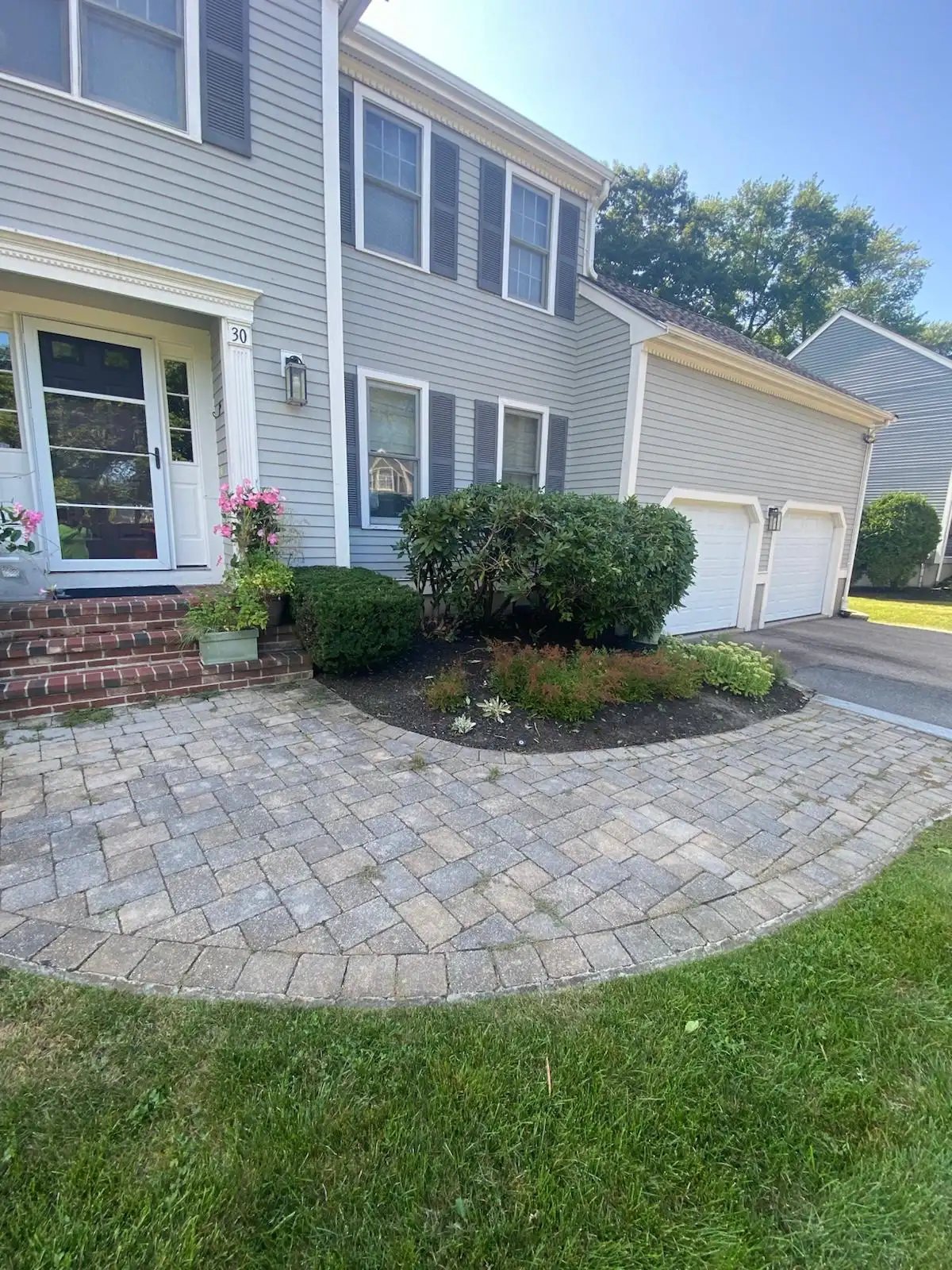 Paver walkway and maintained shrubs at a Massachusetts home